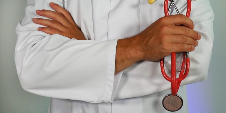 picture of the bottom half of a doctor in white lab coat holding a stethescope